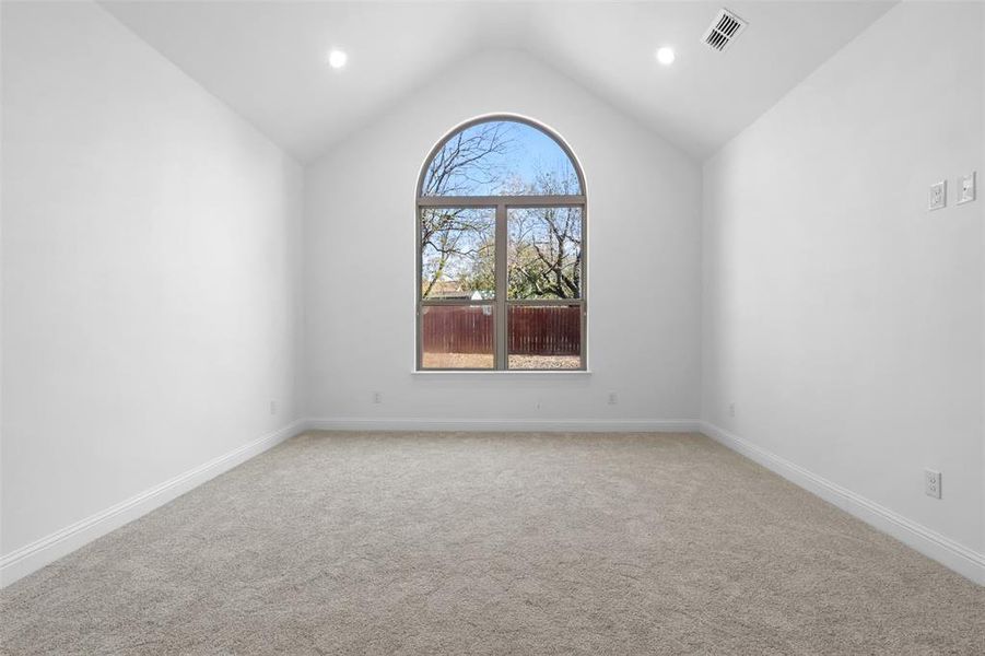 Empty room with carpet and vaulted ceiling