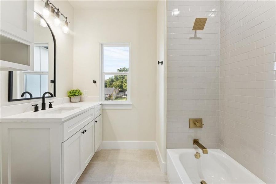 Full bath with shower / washtub combination, vanity, and light tile patterned floors