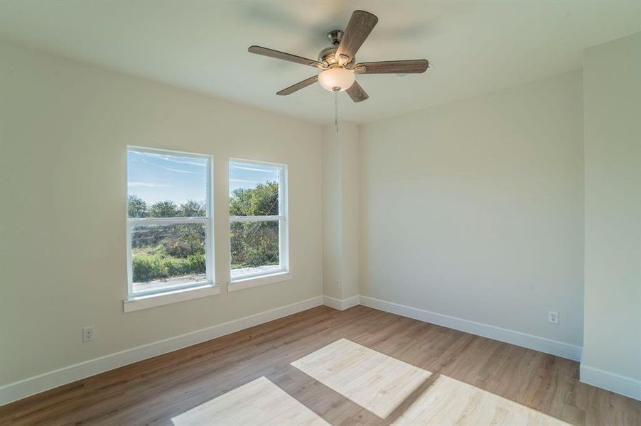 Spare room with light wood finished floors and ceiling fan Spare room with light wood finished floors and ceiling fan
