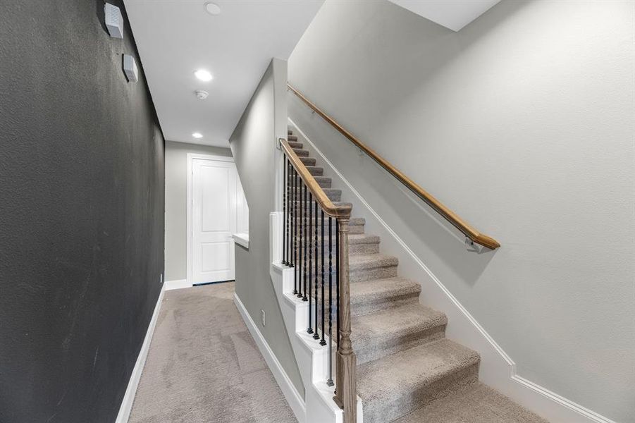 Plush carpeted stairs lead you gracefully upward to the fourth and final level, where you’ll find the second bedroom and a full bathroom.