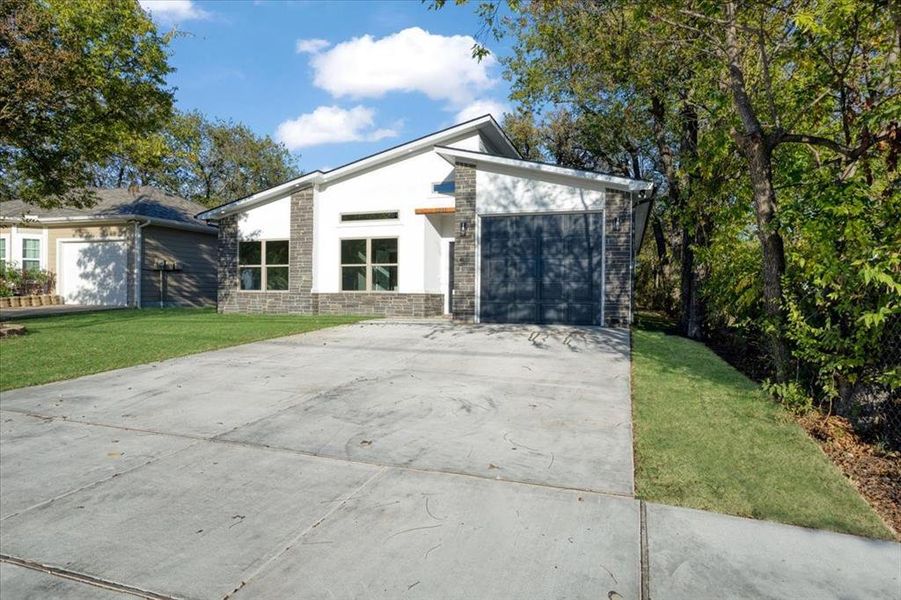 View of front of home featuring a front yard and a garage