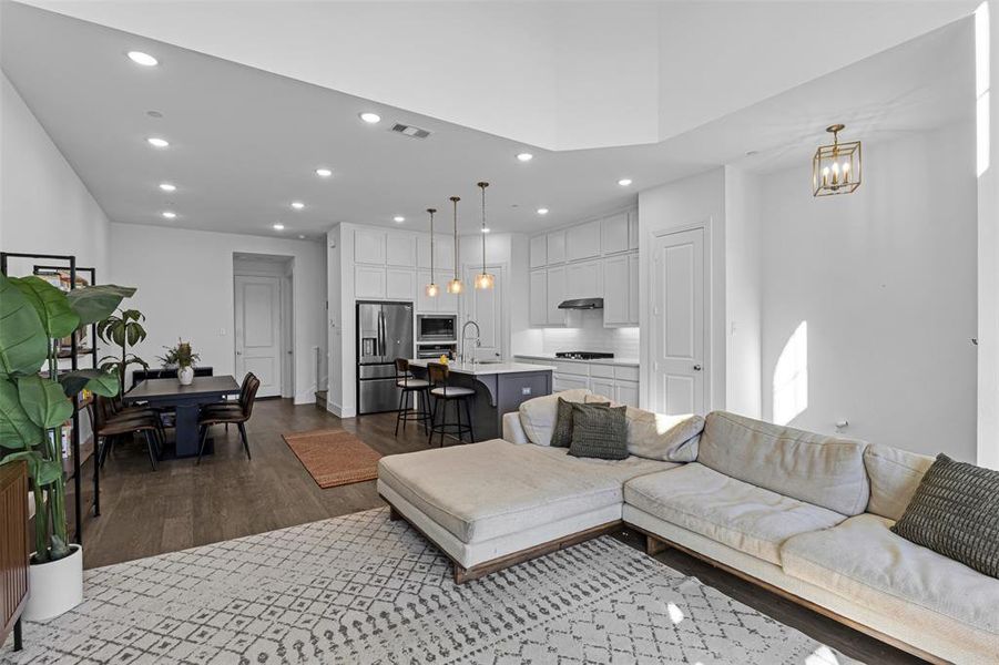 Living area featuring recessed lighting, dark wood-style floors, and a chandelier