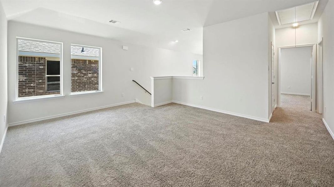 Spare room featuring attic access, light carpet, and recessed lighting