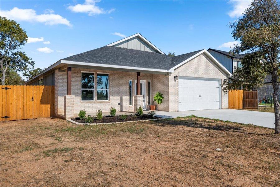 Ranch-style house featuring a gate, covered porch, driveway, and brick siding