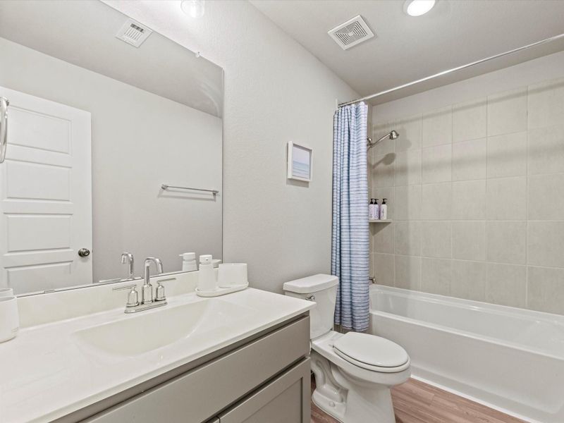 Full secondary bathroom with single vanity and tub-shower combination.
