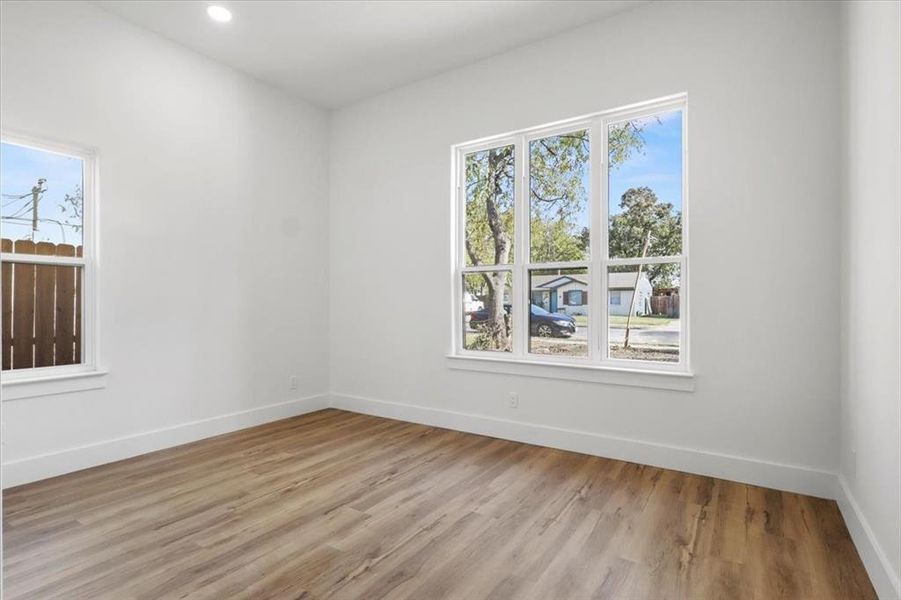 Unfurnished room featuring healthy amount of natural light, light wood finished floors, and recessed lighting