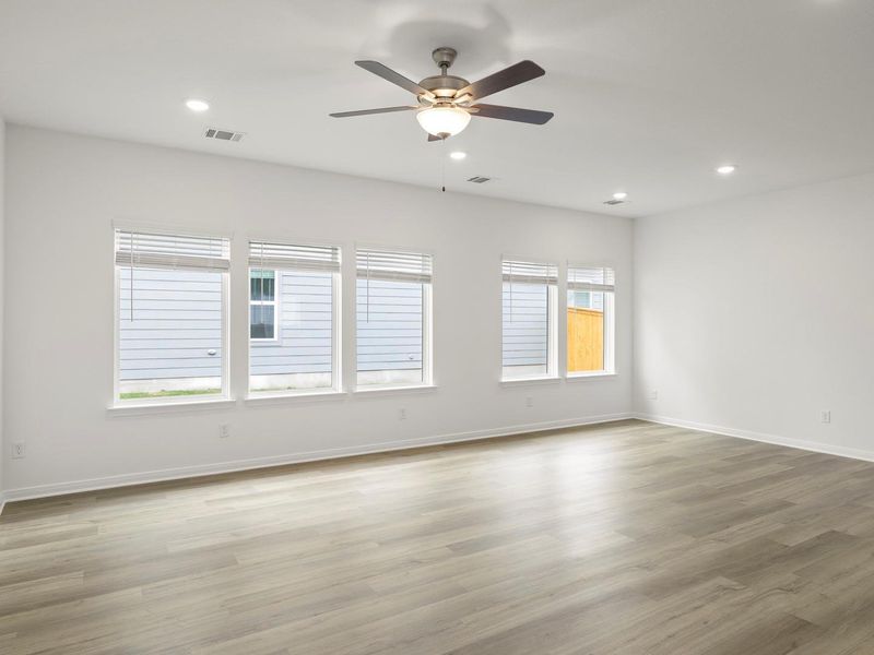 A well-lit room showcasing neutral flooring and ample natural illumination.