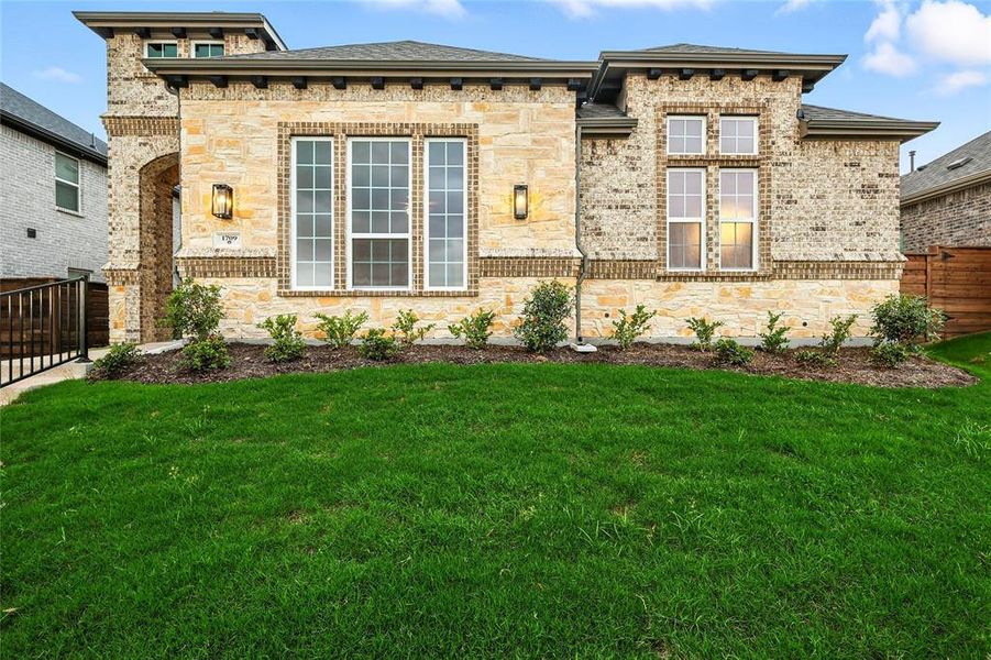 View of front of home featuring brick siding, stone siding, and roof with shingles