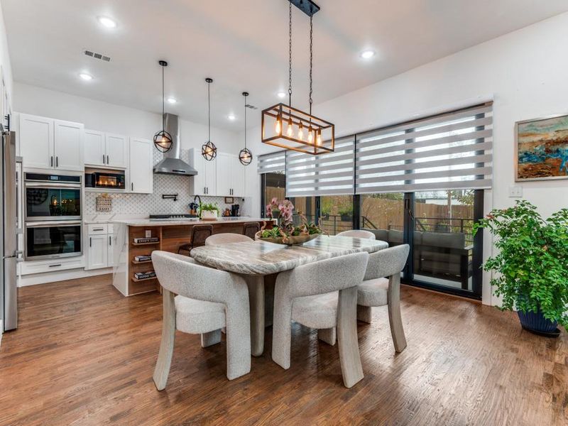 Dining space with dark wood-style floors and recessed lighting
