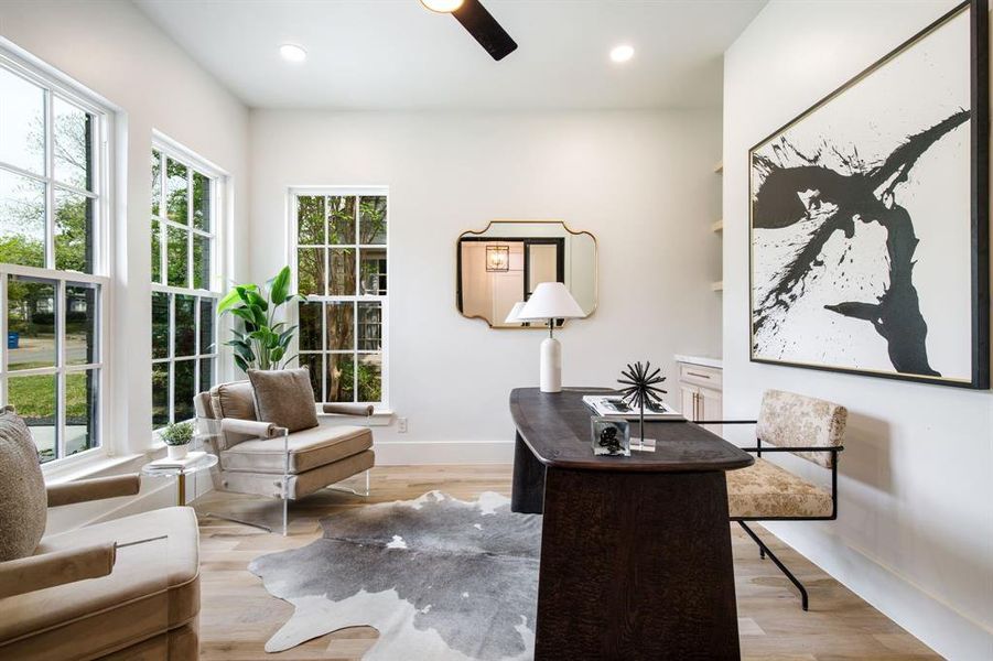 Bright room featuring multiple grid-paned windows, recessed lighting, and light wood-finish flooring Bright room featuring multiple grid-paned windows, recessed lighting, and light wood-finish flooring