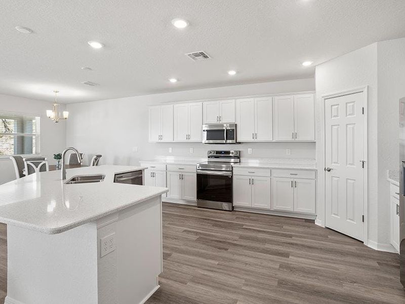 The spacious, open kitchen includes a walk-in pantry and a counter-height butterfly island - Wesley II by Highland Homes The spacious, open kitchen includes a walk-in pantry and a counter-height butterfly island - Wesley II by Highland Homes