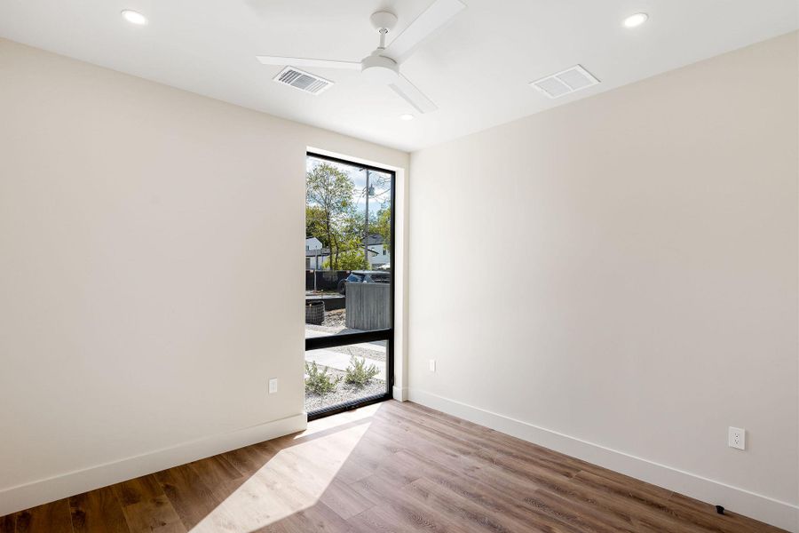 Empty room featuring wood finished floors, ceiling fan, and recessed lighting