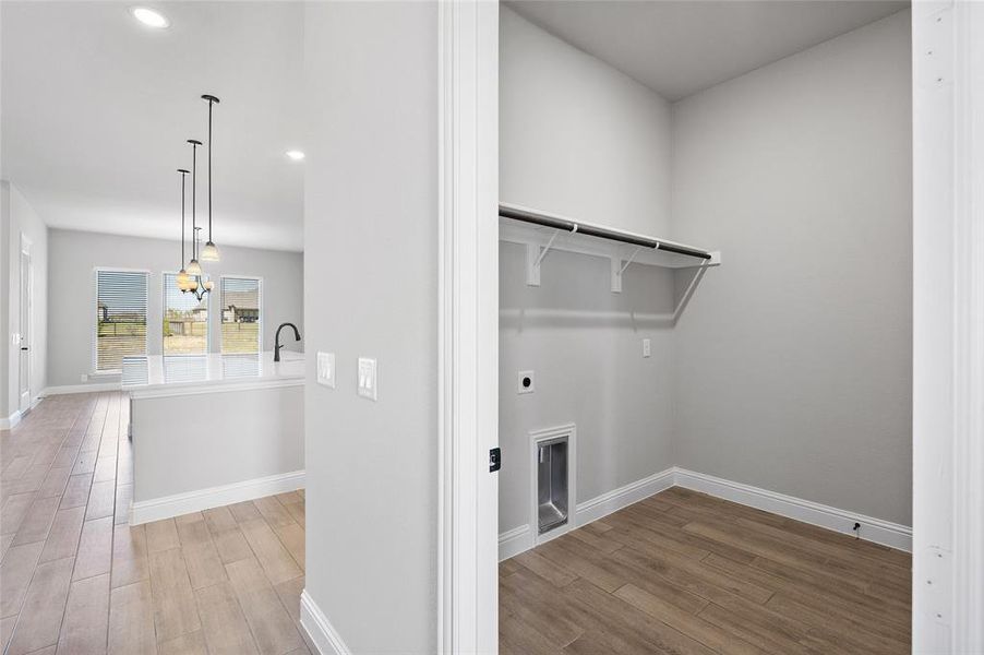 Laundry area with light wood-type flooring, recessed lighting, and hookup for an electric dryer