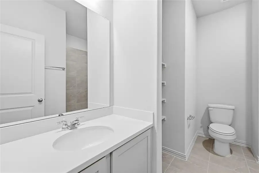 Full bath with vanity and light tile patterned flooring