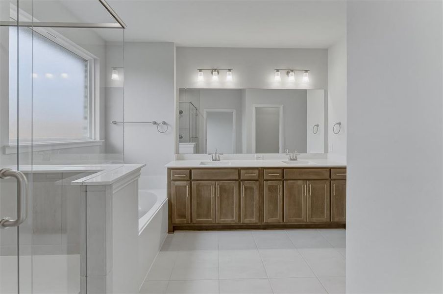 Contemporary bathroom featuring a spacious dual vanity with wood-finish cabinetry and a framed mirror