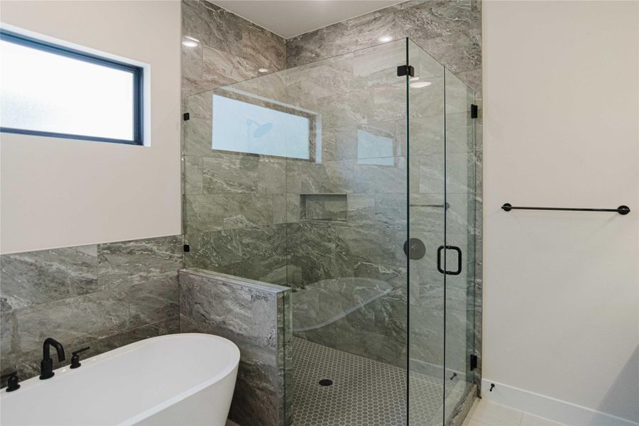 Full bathroom with a freestanding bath and a marble finish shower