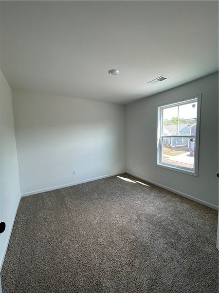 This cozy bedroom features plush carpeting and a s