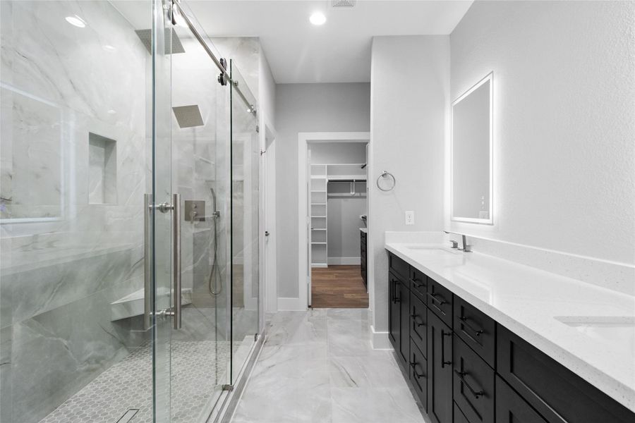 The walk-in shower, framed in glass and marble-style tile, gives you a daily dose of luxury while leading straight into your roomy closet.