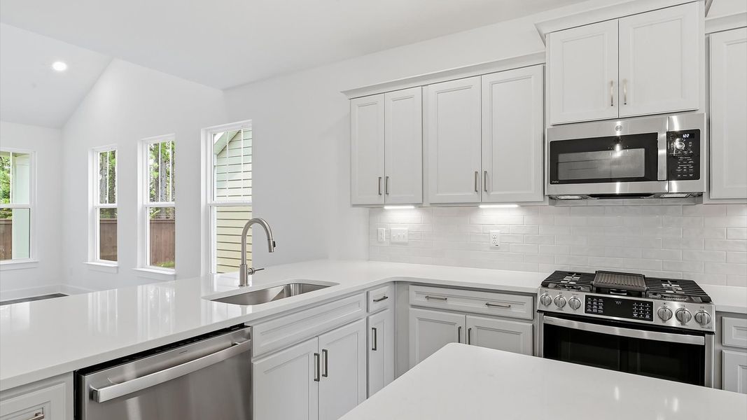 Highly skilled design choices create a clean, open kitchen with a central island Highly skilled design choices create a clean, open kitchen with a central island