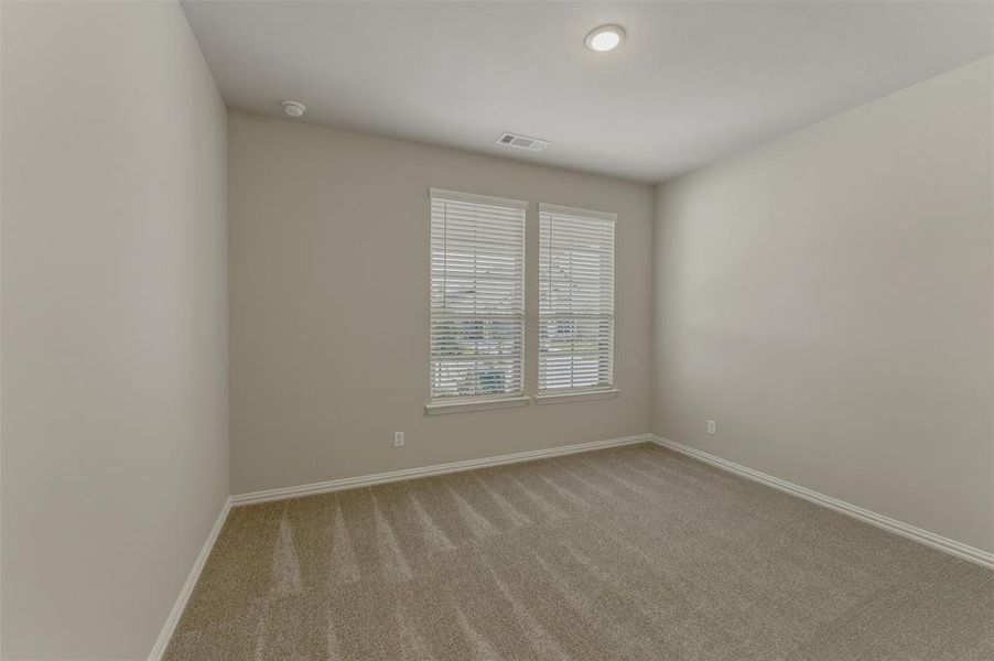 Room featuring neutral wall tones, textured carpeting, and white trim