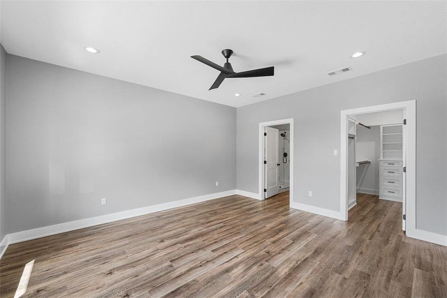 Unfurnished bedroom with wood finished floors, a walk in closet, recessed lighting, ceiling fan, and a closet
