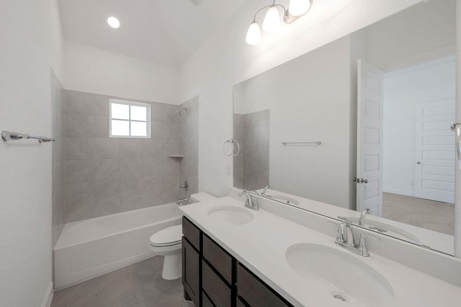 Bathroom with double vanity, shower / washtub combination, tile patterned floors, and recessed lighting