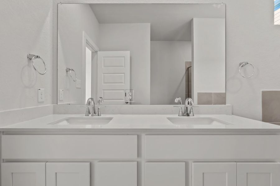 A bathroom with white cabinets.