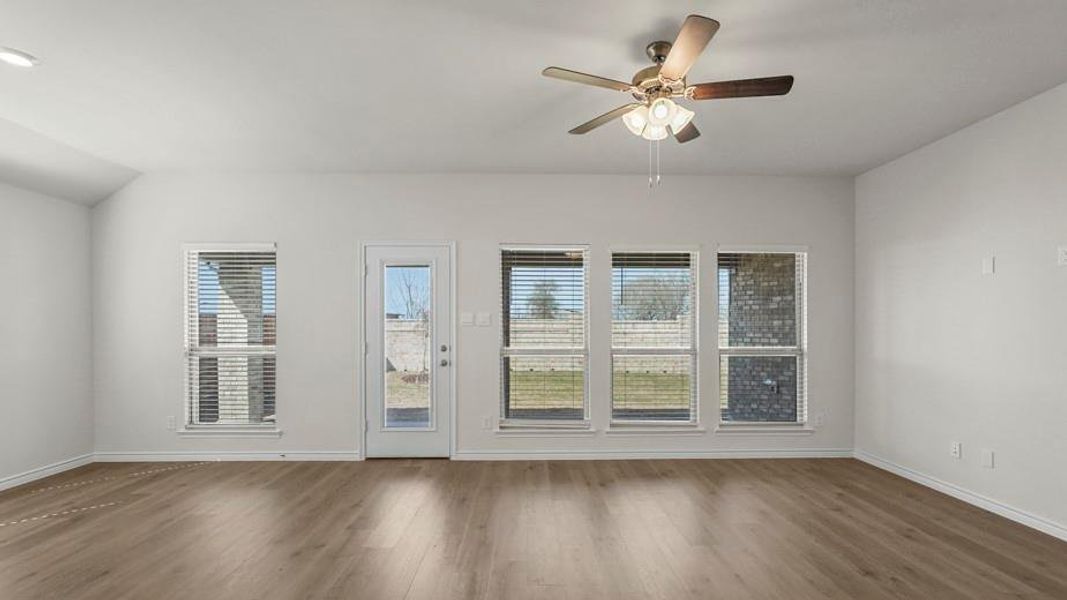 The living area features light wood flooring and white walls