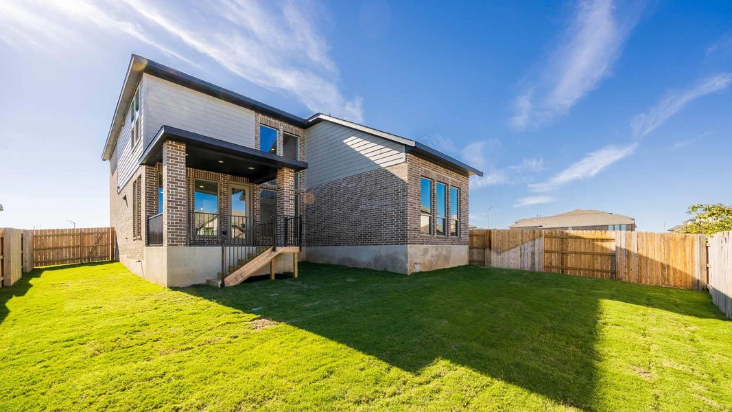 Back of property with a fenced backyard and brick siding Back of property with a fenced backyard and brick siding