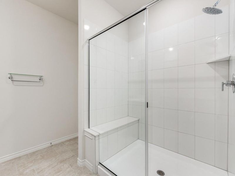 Bathroom featuring a shower stall and baseboards