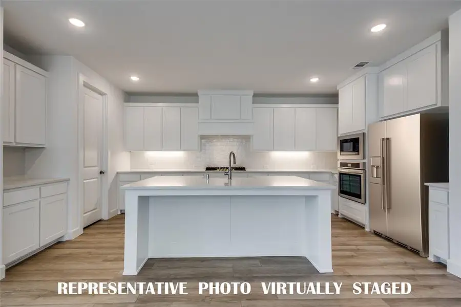 The spacious island is the hub of this fantastic kitchen!  REPRESENTATIVE PHOTO VIRTUALLY STAGED