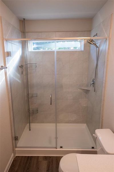 Primary bathroom with double vanity, designer fixtures, and spa-like shower.