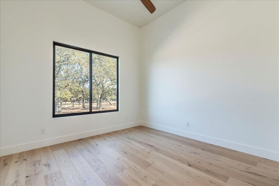 The other guest bedroom is equally spacious, featuring a ceiling fan and a walk-in closet.