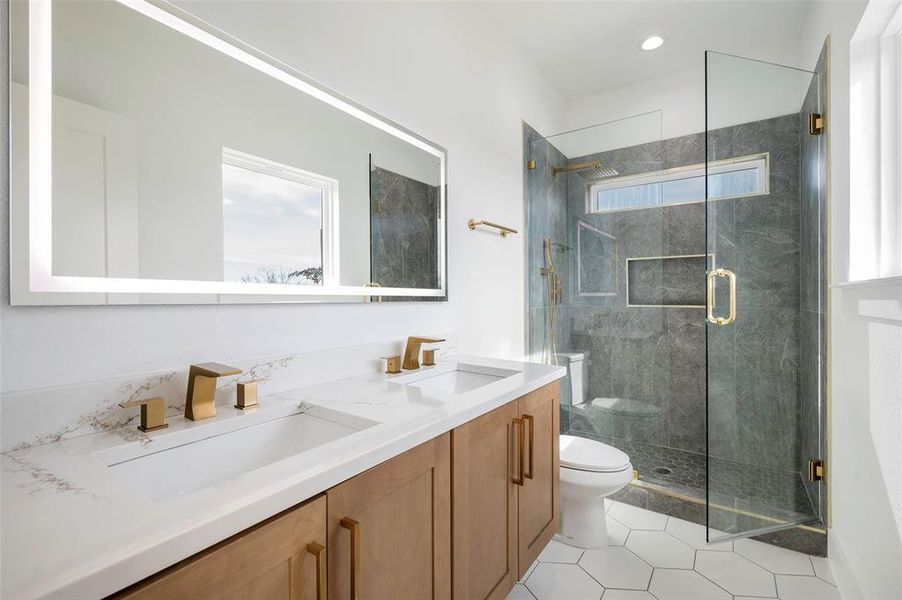 Bathroom with tile patterned floors, vanity, toilet, and a shower with door