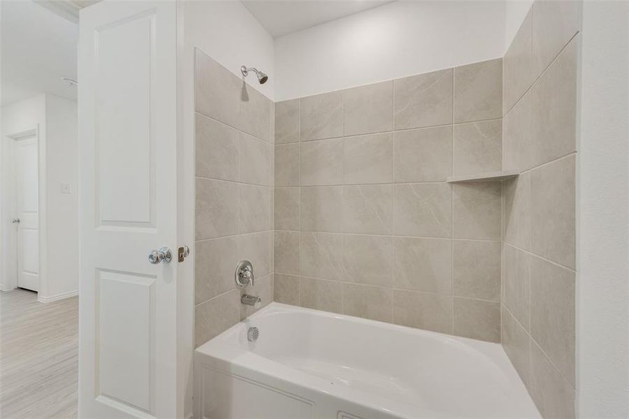 Bathroom featuring hardwood / wood-style floors and tiled shower / bath