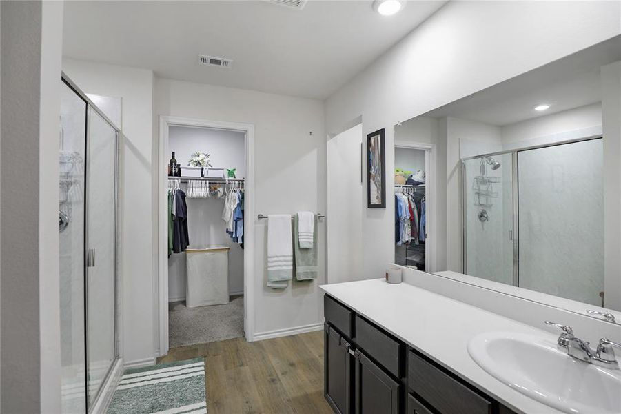 Full bathroom with a spacious closet, dark wood finished floors, a shower stall, vanity, and recessed lighting