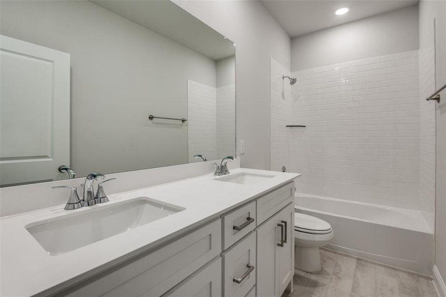 Bathroom featuring a dual vanity with undermount sinks, chrome fixtures, and a white countertop