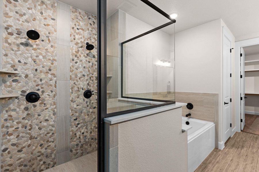 Bathroom with a shower stall, a bath, wood finished floors, and a spacious closet Bathroom with a shower stall, a bath, wood finished floors, and a spacious closet