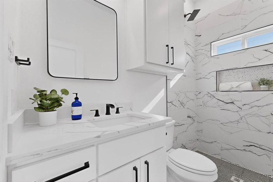 Full bath with vanity and a marble finish shower