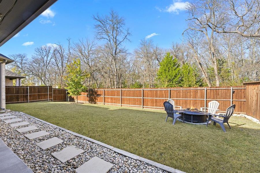 Fenced backyard featuring a fire pit and a patio area