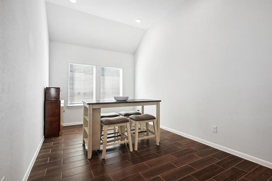 Dining space featuring dark wood-type flooring and lofted ceiling