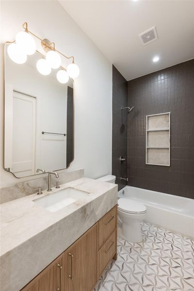 The mother-in-law suite’s private bath is finished with natural stone, full height designer tile and a glass enclosed shower, giving the first floor retreat the same level of finish found throughout the home. The mother-in-law suite’s private bath is finished with natural stone, full height designer tile and a glass enclosed shower, giving the first floor retreat the same level of finish found throughout the home.