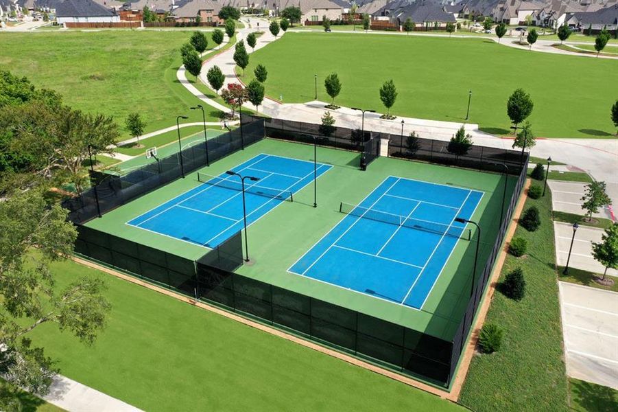 View of tennis court with a residential view