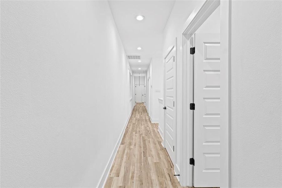 Hallway with light hardwood / wood-style flooring