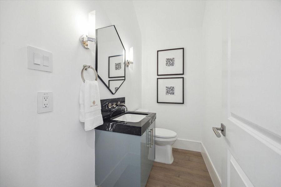 First floor powder features striking Nero Marquina Marble countertop, Kallista luxury fixtures and under-mount sink, and additional storage.