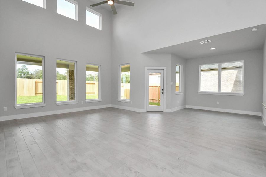 Gather the family and guests together in your lovely living room! Featuring soaring high ceilings, recessed lighting, ceiling fan, custom paint, gorgeous floors, and large windows that provide plenty of natural lighting throughout the day. Sample photo of completed home with similar floor plan. Actual colors and selections may vary. Gather the family and guests together in your lovely living room! Featuring soaring high ceilings, recessed lighting, ceiling fan, custom paint, gorgeous floors, and large windows that provide plenty of natural lighting throughout the day. Sample photo of completed home with similar floor plan. Actual colors and selections may vary.