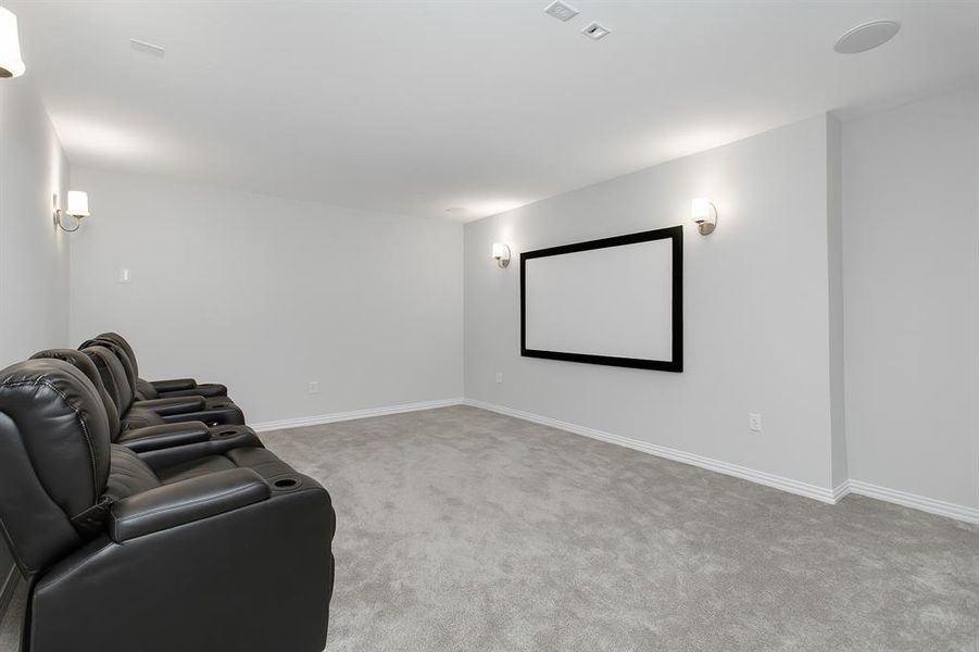 Home theater room featuring carpet and baseboards
