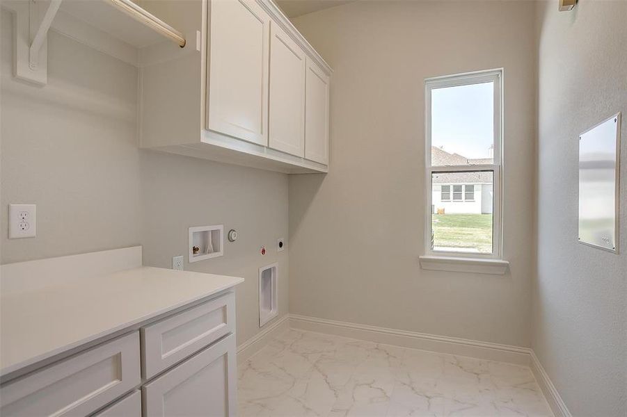 Laundry room with electric dryer hookup, cabinets, hookup for a washing machine, light tile patterned floors, and hookup for a gas dryer