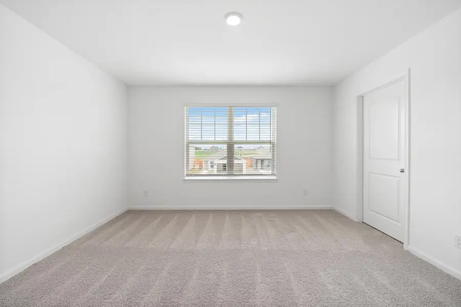 Spare room featuring light colored carpet and baseboards