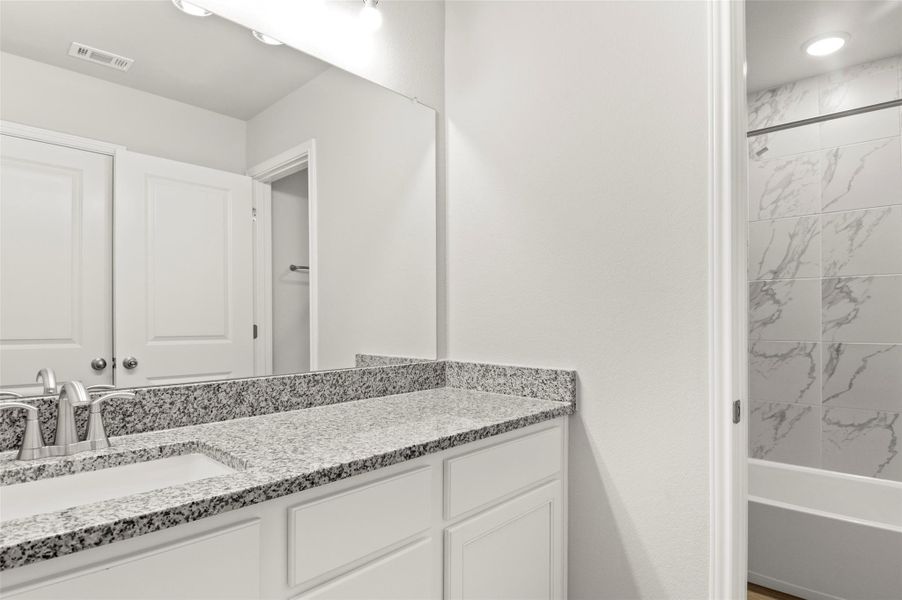 Bathroom with vanity and bathtub / shower combination